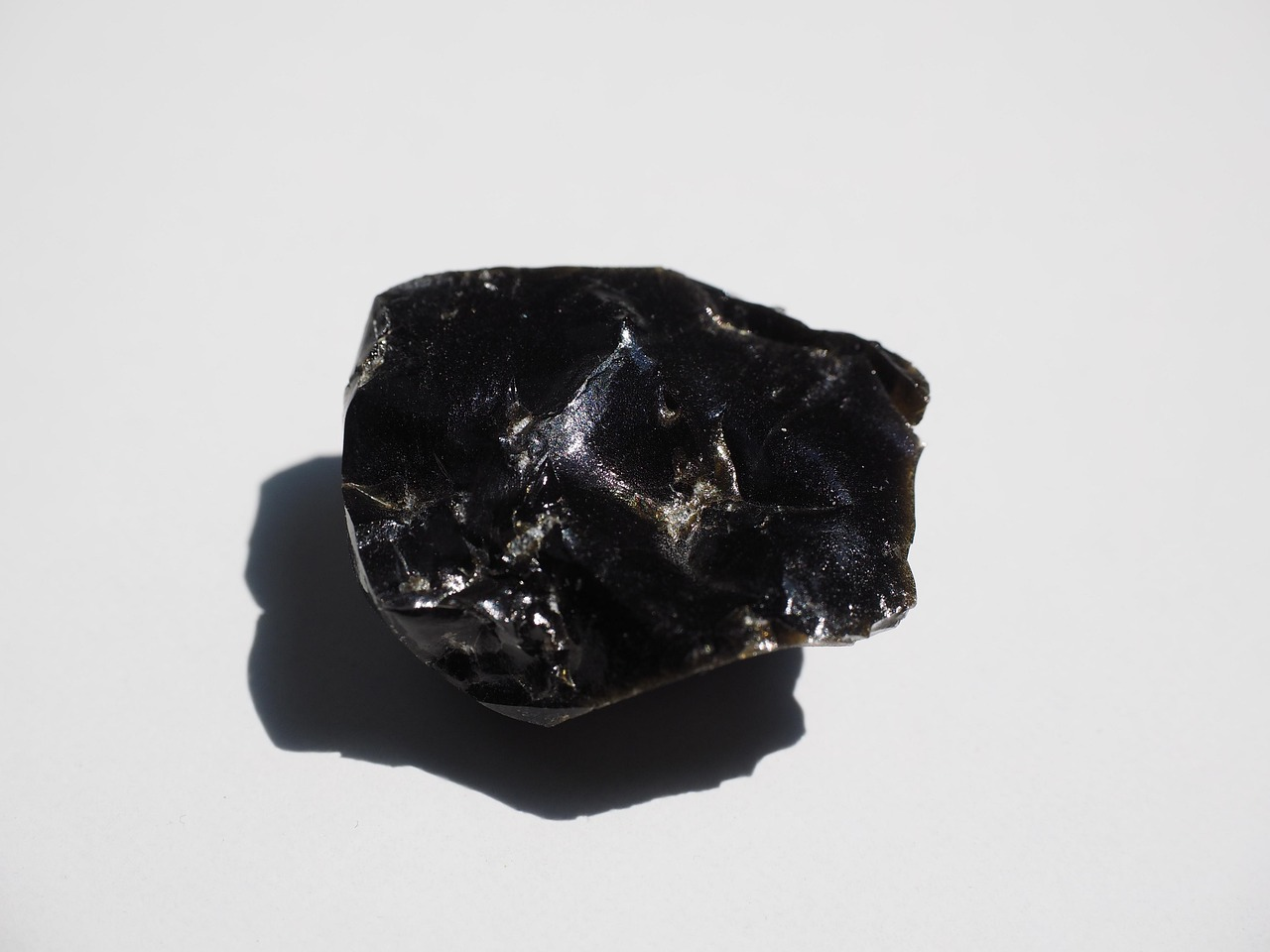 Black Obsidian raw crystal on natural surface.